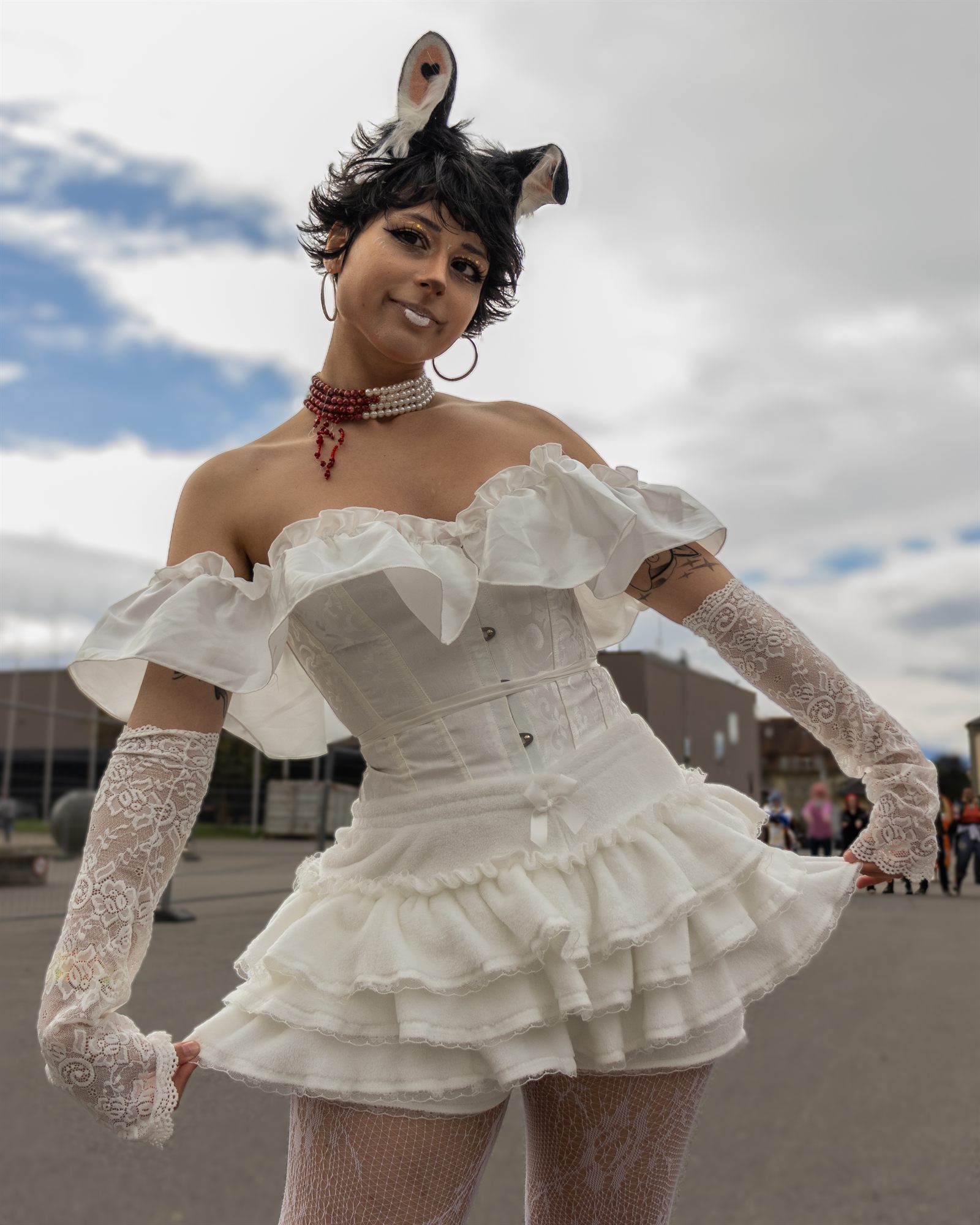 Portrait d’une cosplayeuse en robe blanche à volants et oreilles d’animal