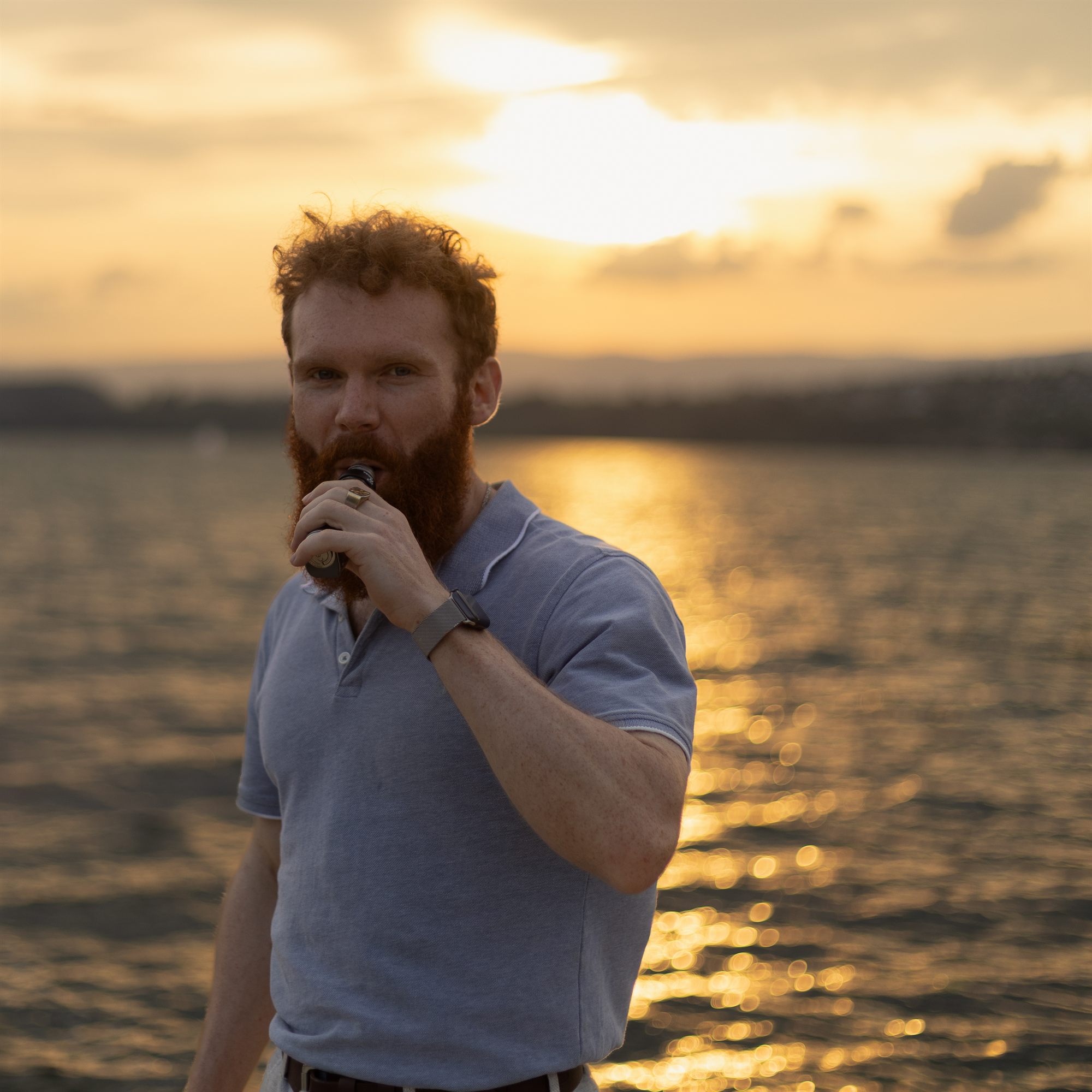 Portrait de Quentin Bossard au bord du lac, à contre-jour au coucher du soleil